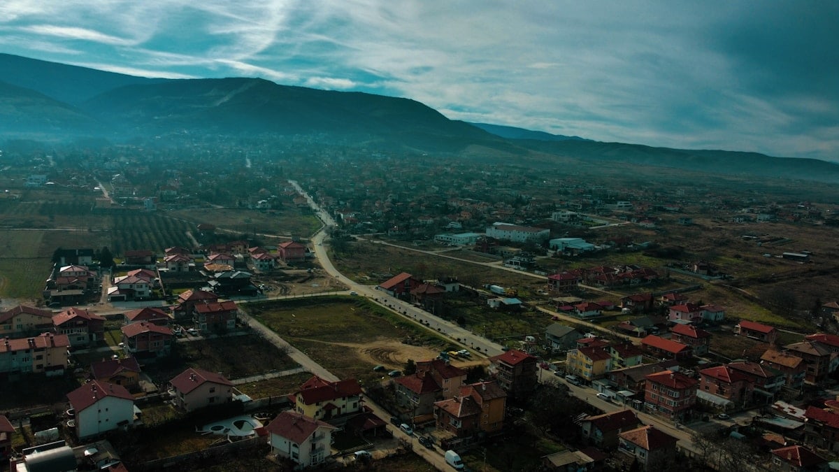 an aerial view of a town with mountains in the background